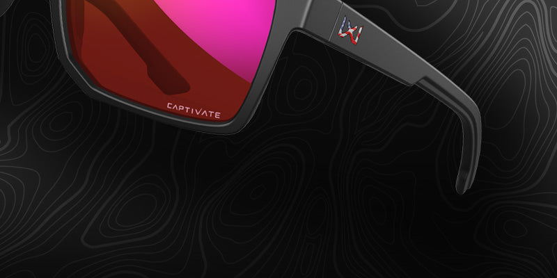 Black sunglasses with a red lens on a dark background